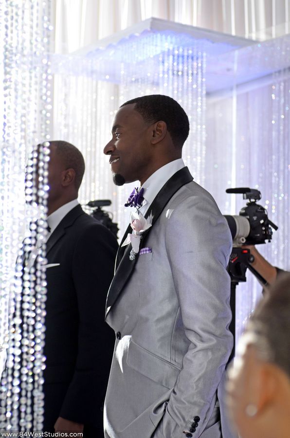 Handsome groom in a silvery gray and black tuxedo looks modern and stylish while still looking formal and elegant.